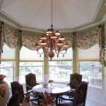 Custom draperies in a room with a table and chandelier