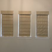 Slat front Roman shades with blackout lining darken this master bedroom. Slat front Roman shades