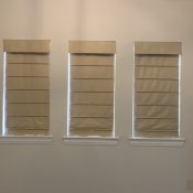 Slat front Roman shades with blackout lining darken this master bedroom. Slat front Roman shades