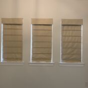 Slat front Roman shades with blackout lining darken this master bedroom. Slat front Roman shades